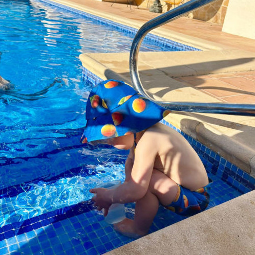 Kind mit Hut im Pool